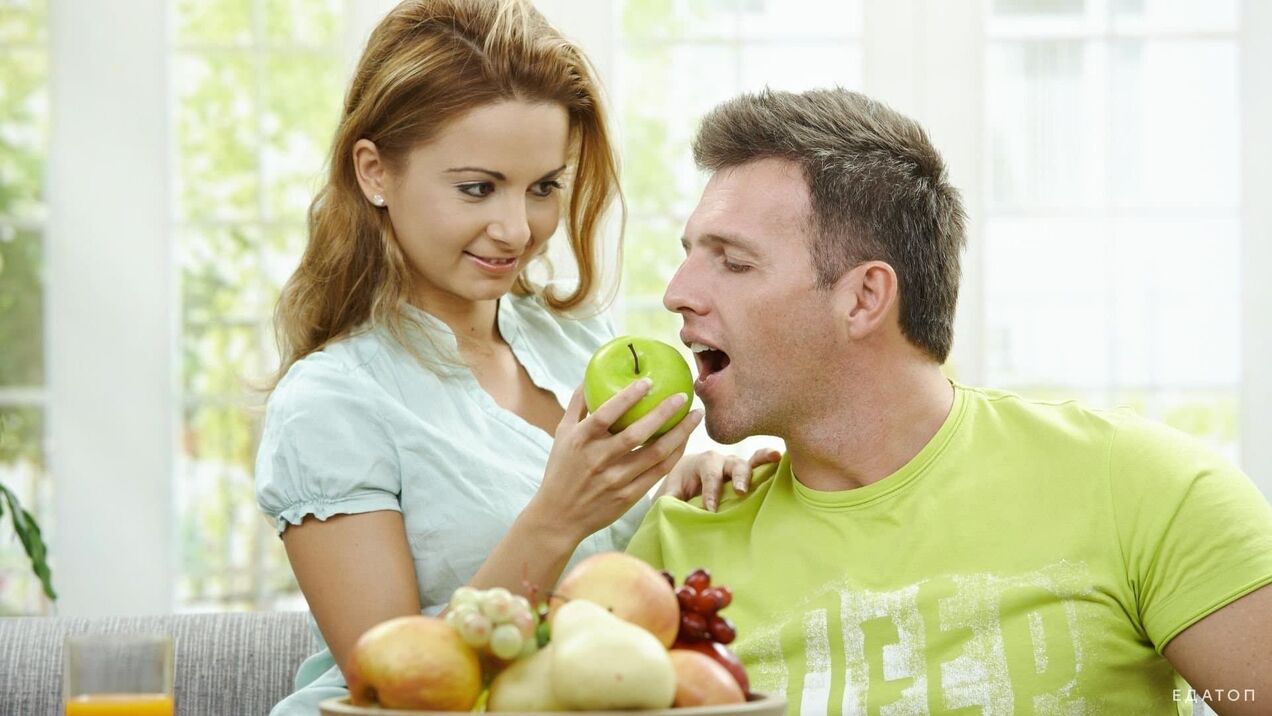 Fata hrănește bărbatului cu mâncare sănătoasă
